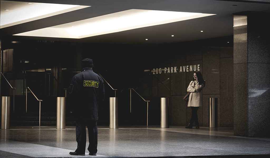 A security guard watches a building. police and security professional mental health and de-escalation training.